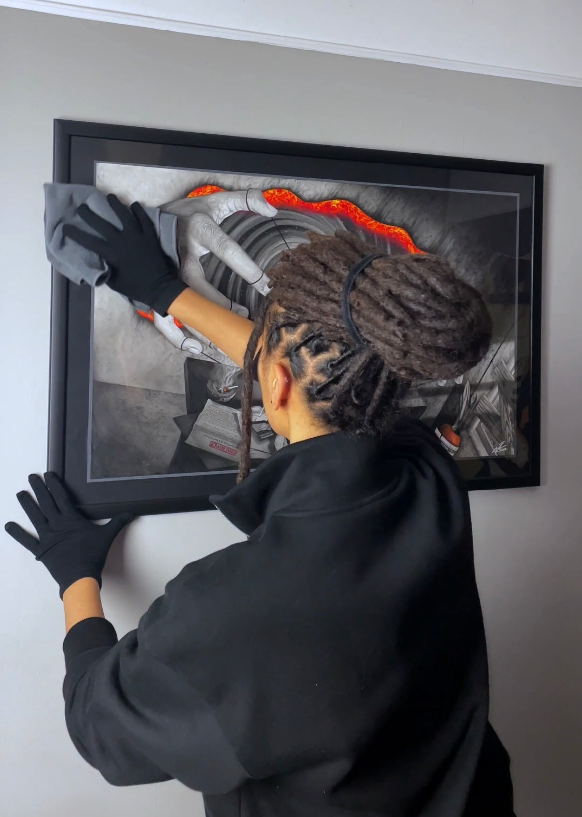 Professional visual artist Naomi Richards wiping her framed original of 'At Your Command' with a cloth