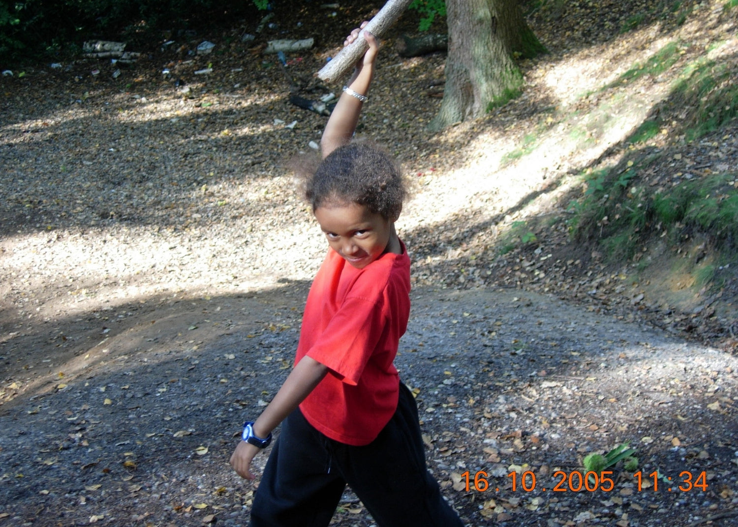Visual artist Naomi Richards as a child doing a superhero pose in the woods
